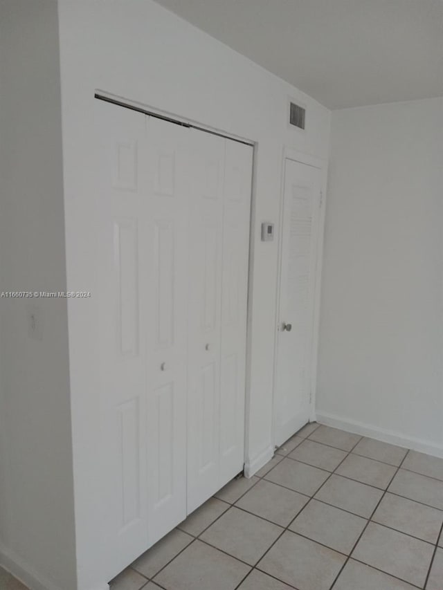 unfurnished bedroom with light tile patterned floors and a closet