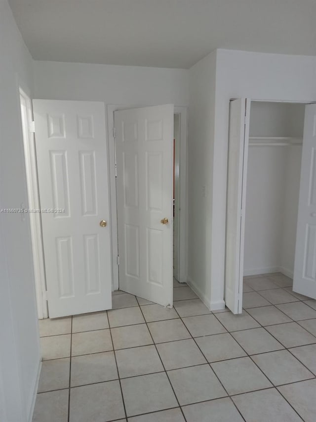 unfurnished bedroom featuring light tile patterned flooring and a closet