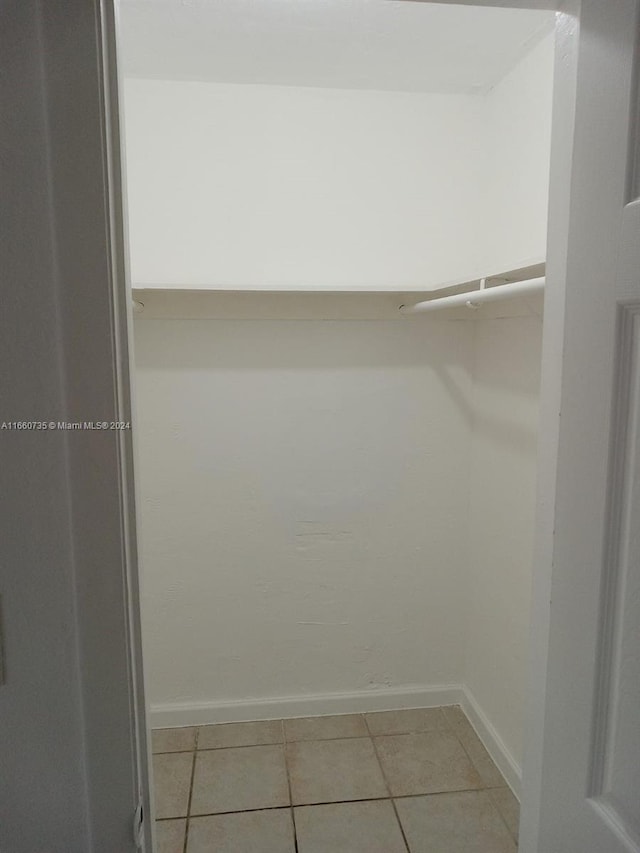 walk in closet with light tile patterned floors