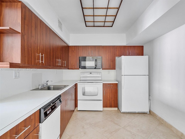 kitchen featuring white appliances, light tile patterned flooring, and sink