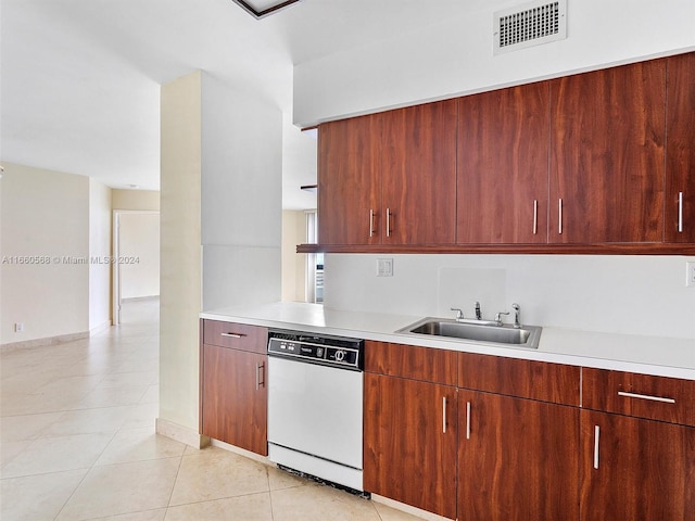 kitchen with white dishwasher, sink, and light tile patterned flooring