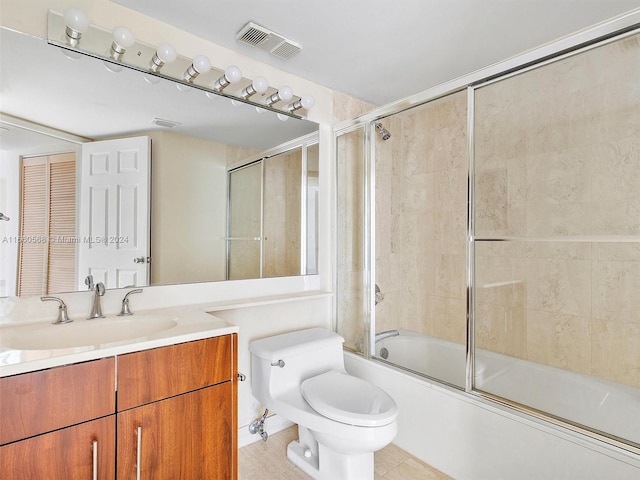 full bathroom with combined bath / shower with glass door, vanity, toilet, and tile patterned floors