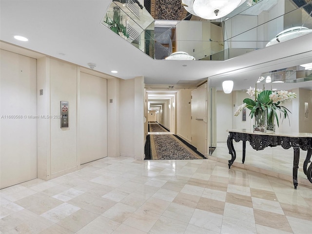 foyer entrance featuring a towering ceiling and elevator