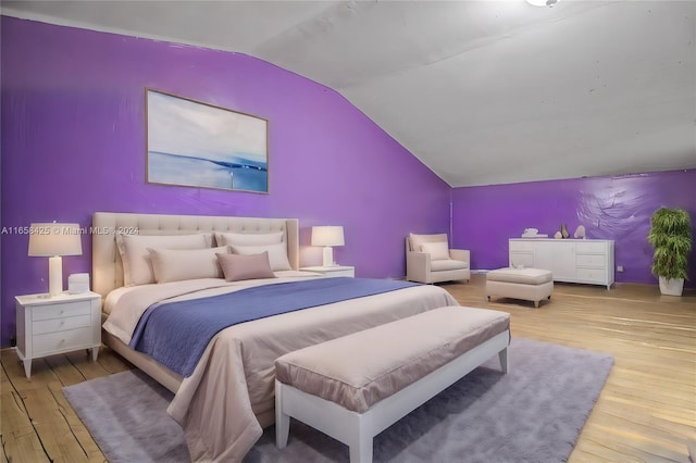 bedroom with vaulted ceiling and light hardwood / wood-style floors