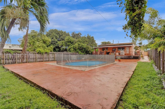 view of swimming pool featuring a wooden deck and a yard