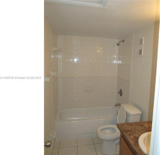 full bathroom featuring vanity, tiled shower / bath combo, toilet, and tile patterned flooring