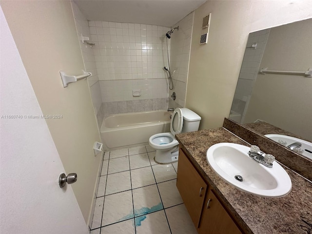 full bathroom with tile patterned floors, tiled shower / bath combo, vanity, and toilet