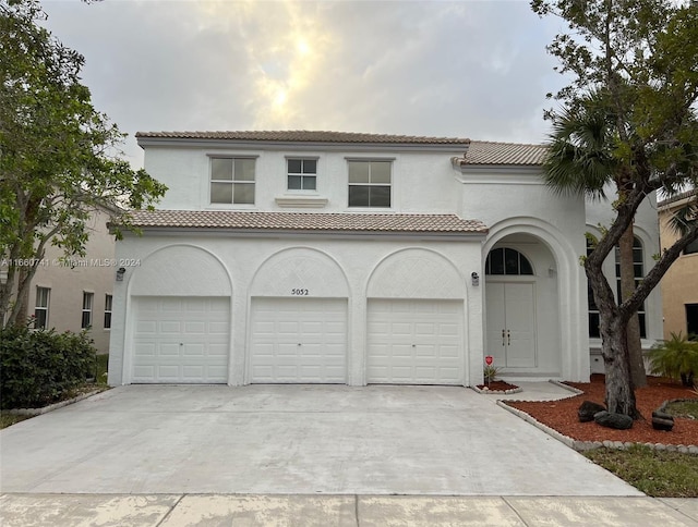 mediterranean / spanish-style home with a garage