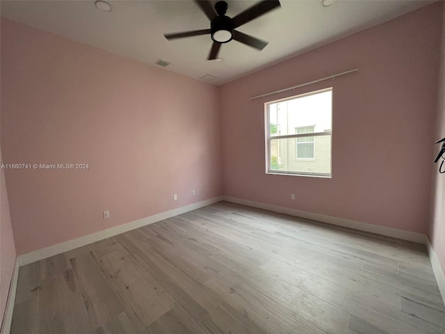 empty room with ceiling fan and light hardwood / wood-style flooring