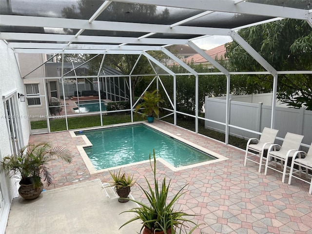 view of swimming pool with a lanai and a patio area