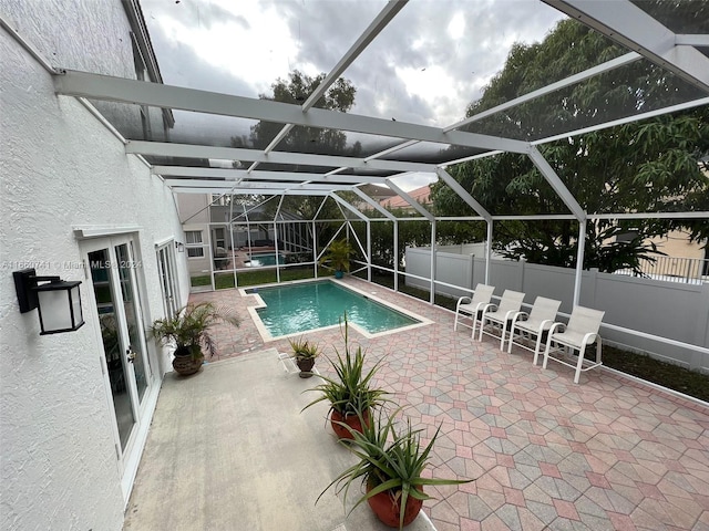 view of pool featuring glass enclosure and a patio area