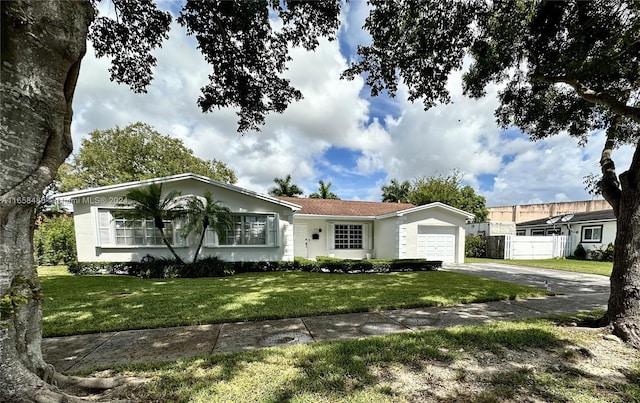 single story home featuring a garage and a front yard