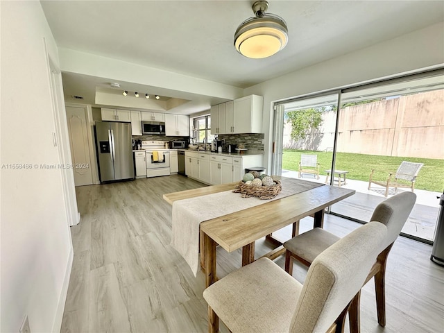 dining area with light wood-type flooring and sink