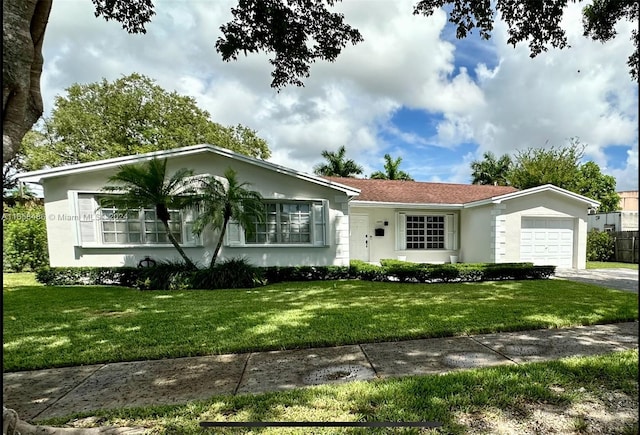 single story home featuring a garage and a front lawn