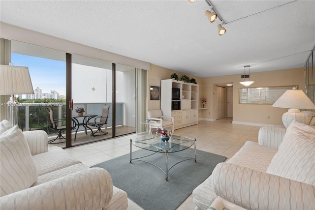 living room featuring a textured ceiling, light tile patterned flooring, and rail lighting