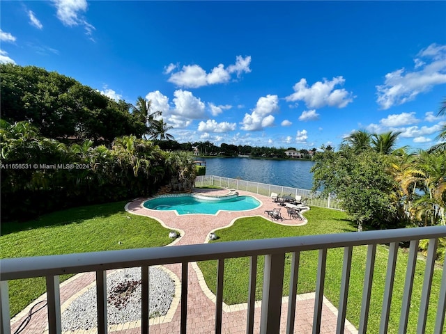 view of swimming pool with a patio, a water view, and a lawn