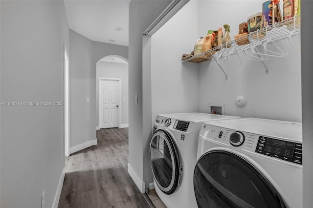 clothes washing area with hardwood / wood-style floors and washer and dryer