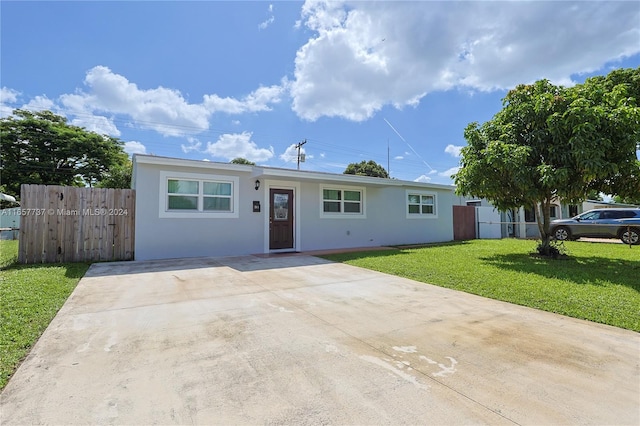 single story home featuring a front lawn