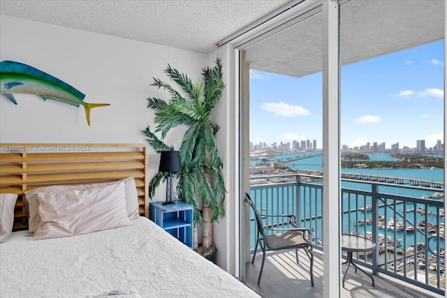 carpeted bedroom featuring a textured ceiling, a water view, and floor to ceiling windows