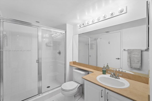 bathroom featuring tile patterned flooring, walk in shower, vanity, and toilet