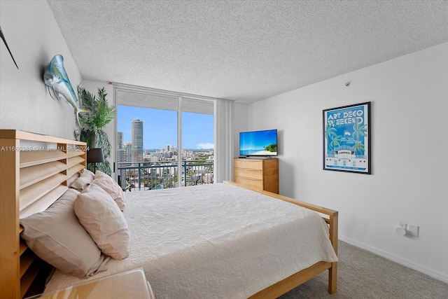 carpeted bedroom featuring a textured ceiling, access to outside, and expansive windows