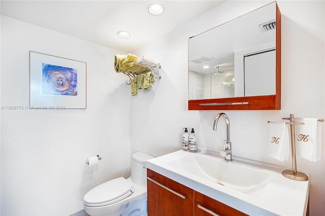 bathroom featuring vanity, a shower, and toilet