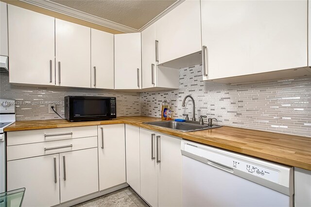 kitchen with white appliances, sink, wooden counters, and white cabinets