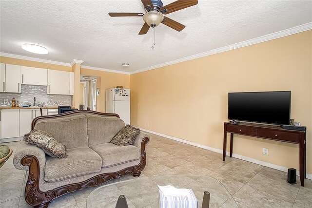 tiled living room with a textured ceiling, crown molding, sink, and ceiling fan