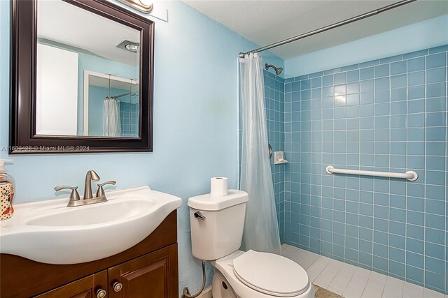 bathroom featuring a shower with shower curtain, vanity, and toilet