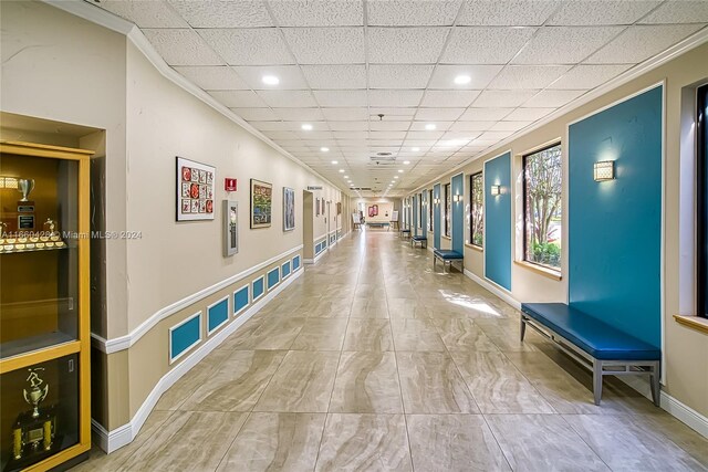 corridor featuring ornamental molding and a drop ceiling