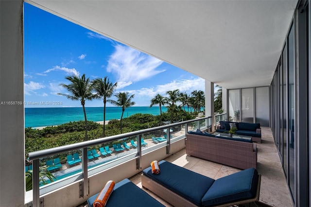 balcony featuring a water view and an outdoor living space