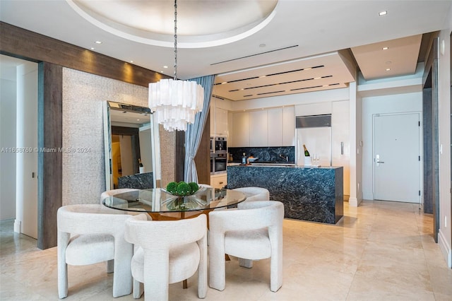 dining room featuring light tile patterned flooring, a tray ceiling, and a chandelier