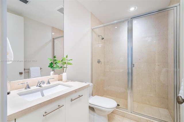 bathroom with vanity, tile patterned flooring, toilet, and a shower with door