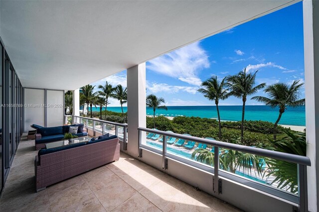 balcony with a water view and a view of the beach