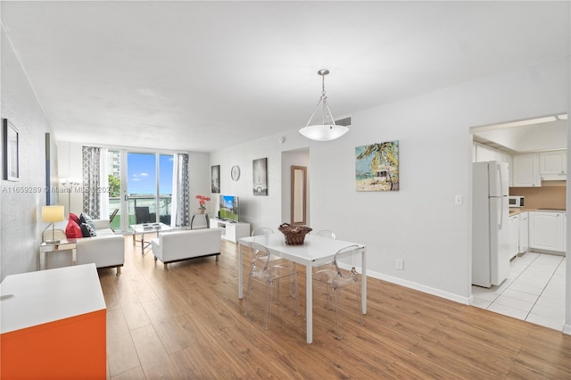 3801 S Ocean Dr Unit 2Z, Hollywood, FL 33019 - dining space featuring light wood-style flooring, a wall of windows, and baseboards