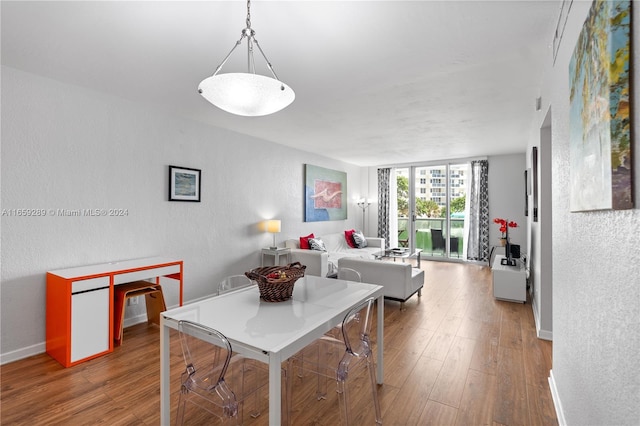 3801 S Ocean Dr Unit 2Z, Hollywood, FL 33019 - dining space featuring a textured wall, wood finished floors, baseboards, and a wall of windows