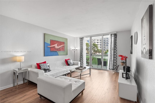 3801 S Ocean Dr Unit 2Z, Hollywood, FL 33019 - living area featuring wood finished floors, a textured wall, expansive windows, and baseboards