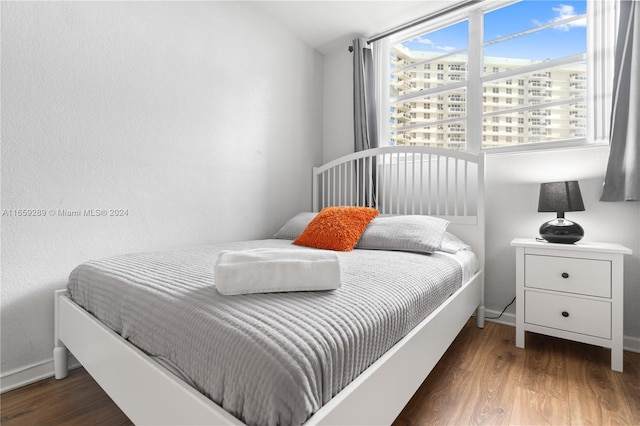 bedroom with dark hardwood / wood-style floors