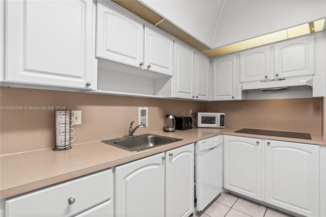 kitchen featuring white appliances, sink, light tile patterned floors, and white cabinets