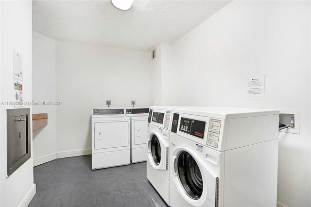 3801 S Ocean Dr Unit 2Z, Hollywood, FL 33019 - community laundry room with washer and dryer, baseboards, and a textured ceiling
