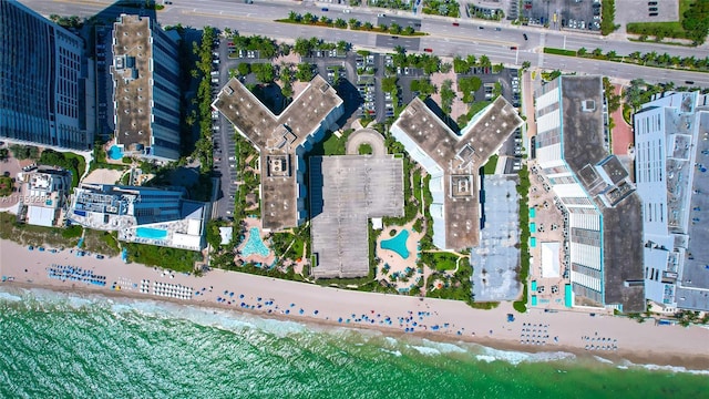 birds eye view of property featuring a water view and a beach view