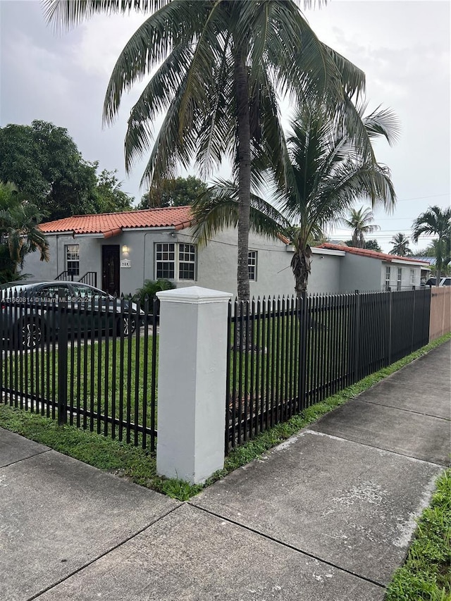 view of front of property featuring stucco siding, a front yard, and a fenced front yard