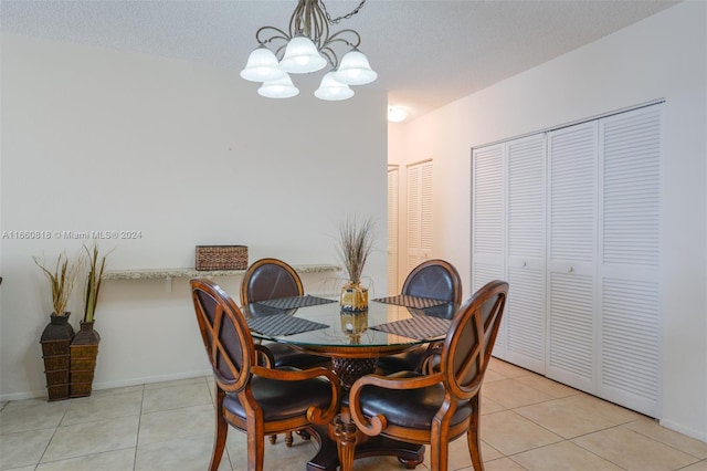 dining area featuring a textured ceiling, light tile patterned floors, and a notable chandelier