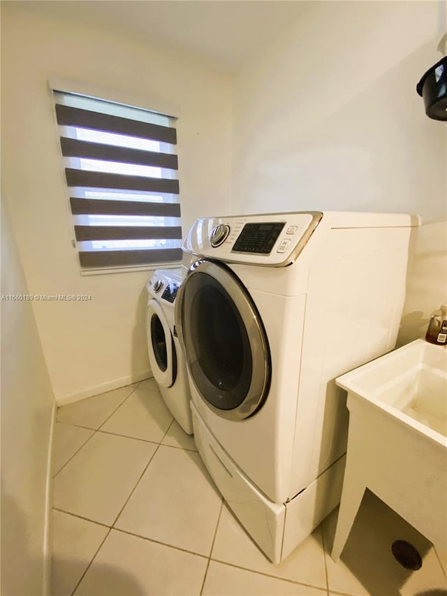 washroom featuring washer and clothes dryer and light tile patterned flooring