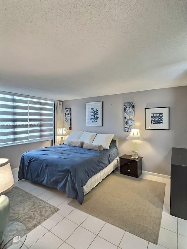 tiled bedroom featuring a textured ceiling