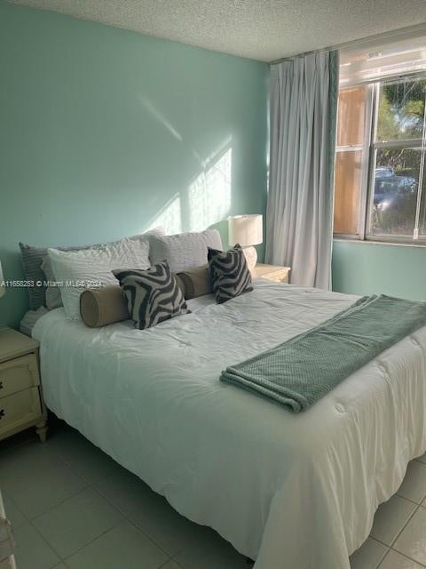 bedroom with a textured ceiling and light tile patterned flooring