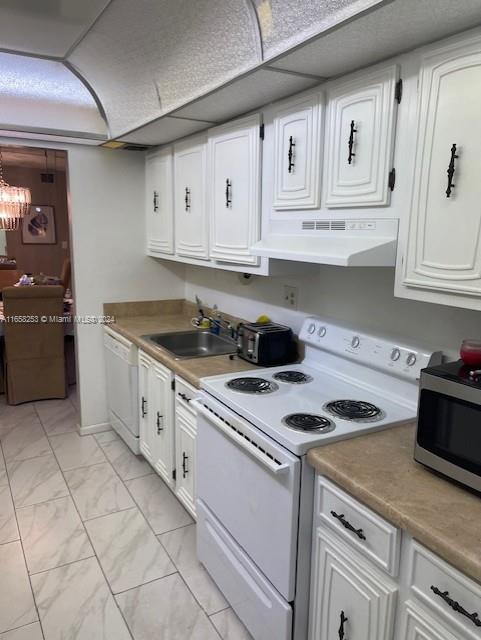 kitchen featuring white cabinets, white appliances, sink, and extractor fan