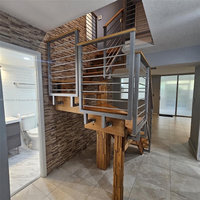 stairway featuring a textured ceiling