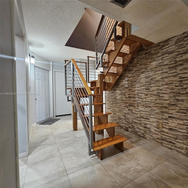 stairway with a textured ceiling