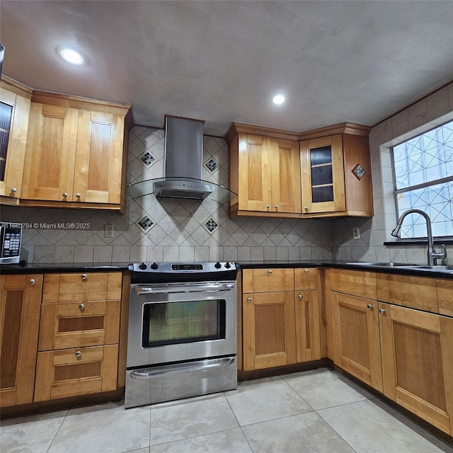 kitchen featuring stainless steel appliances, dark countertops, tasteful backsplash, a sink, and wall chimney exhaust hood